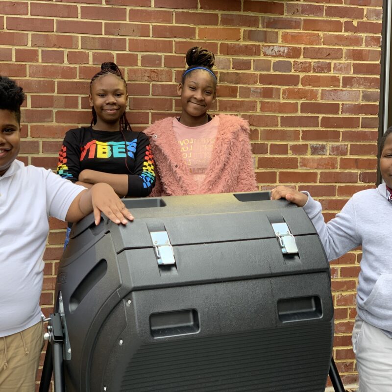 C W Harris Elementary students posing with their new compost tumbler bin