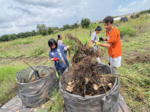 Four high school interns building a compost bioreactor at an urban farm in Austin, Texas
